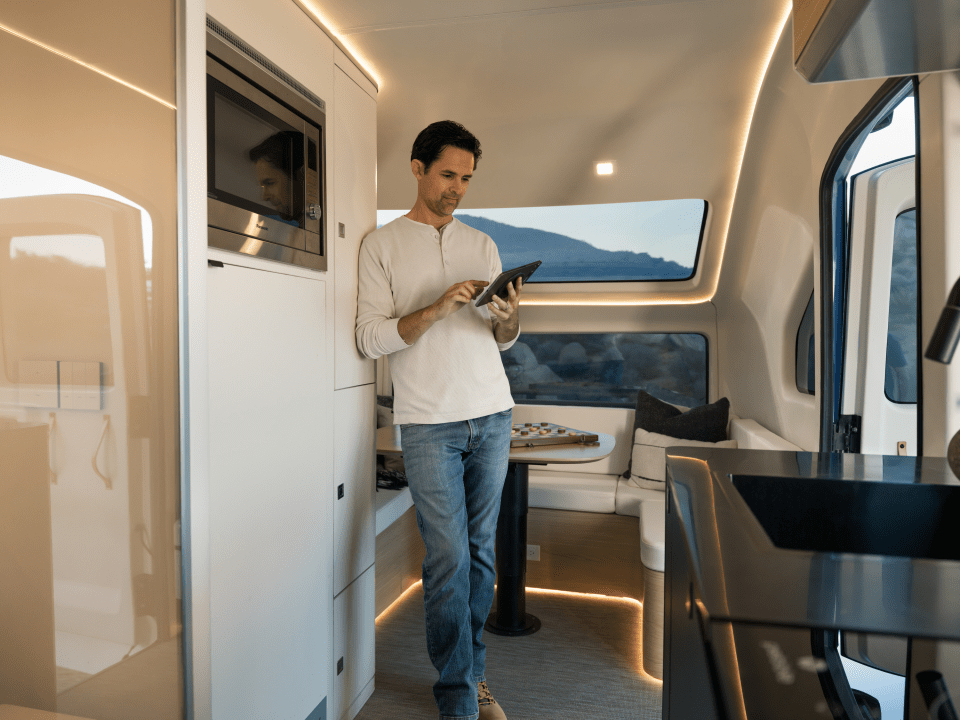 Man using tablet in electric caravan.