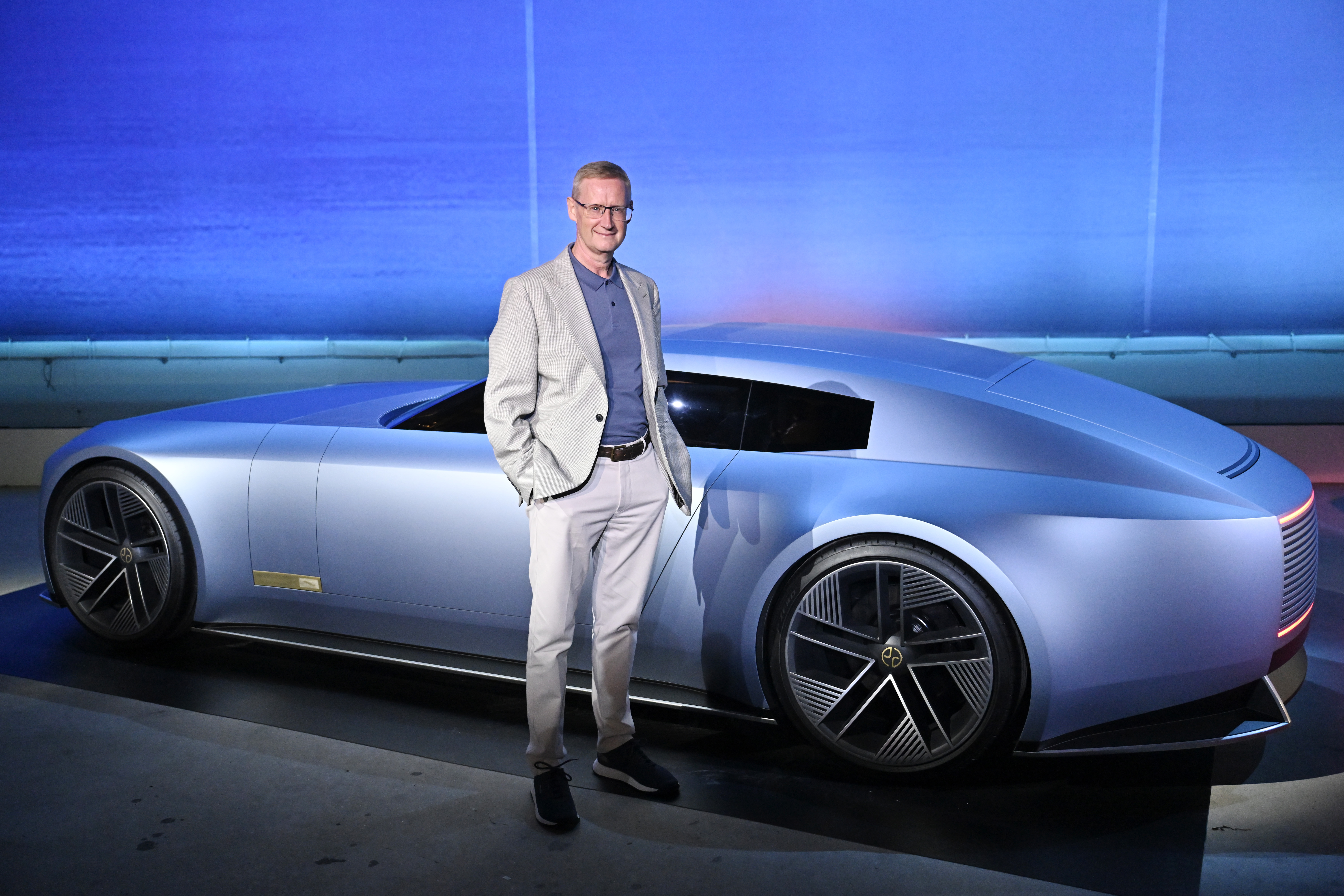 Man standing next to a light blue concept car.