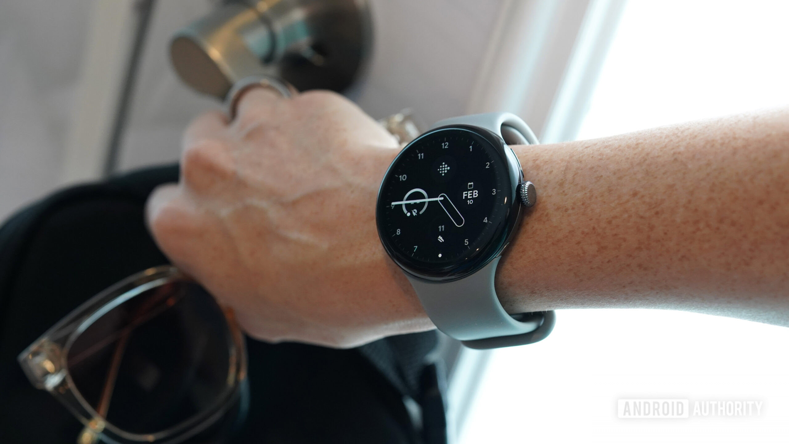 A Google Pixel Watch 3 user leaves the house which a bunch of things in hand.