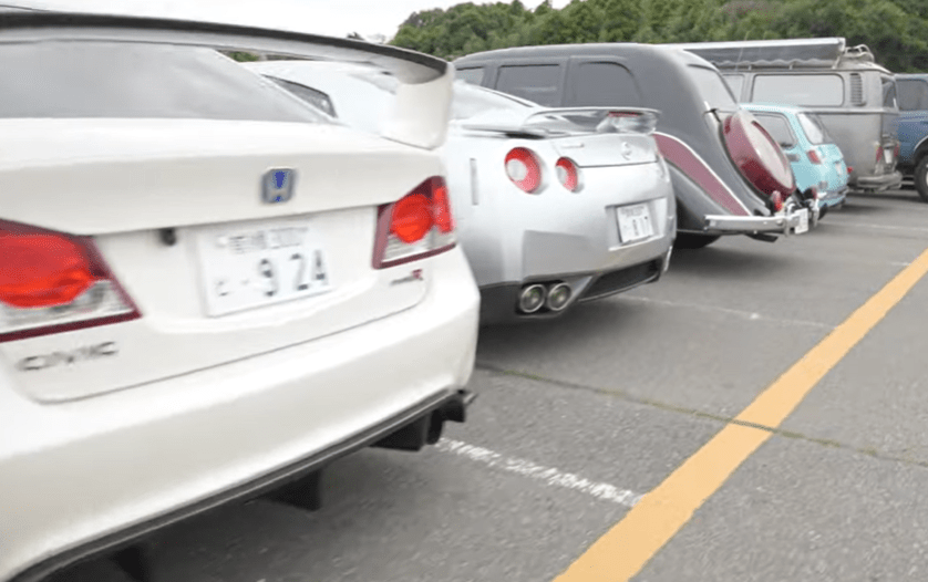 Rear view of several cars parked in a row.