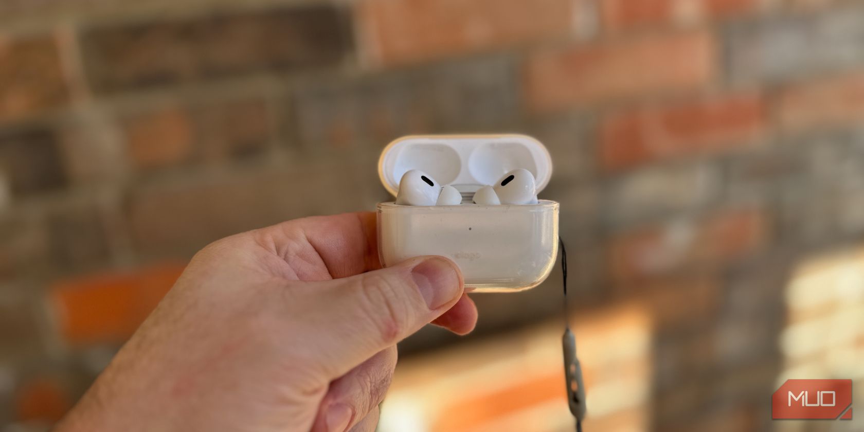 a person holding AirPods Pro enclosed in a case