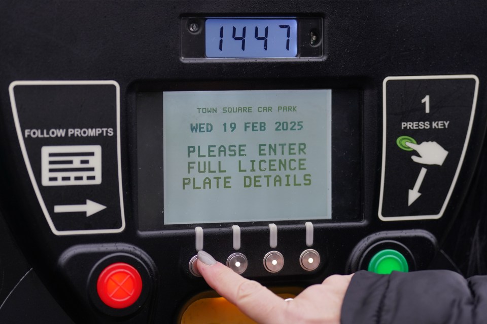 Woman using a parking payment machine.