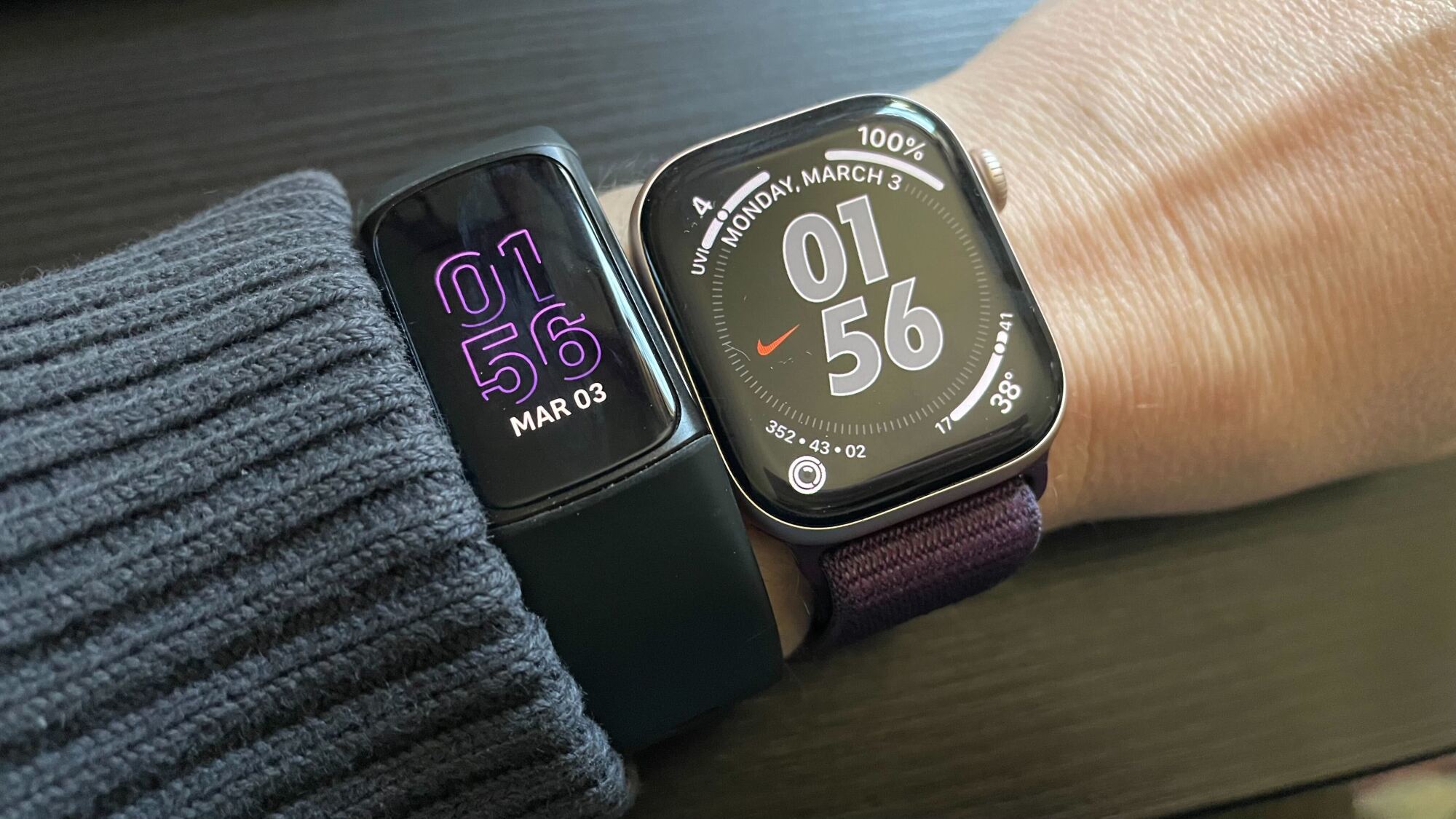 Fitbit with purple numbers, Apple Watch with a darkened version of its watch face.