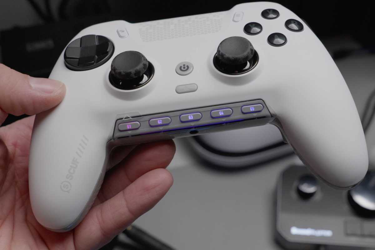 White Scuf wireless gaming controller in hand with worn thumbsticks