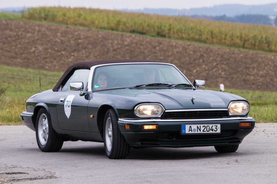 1993 Jaguar XJS convertible driving on a road.