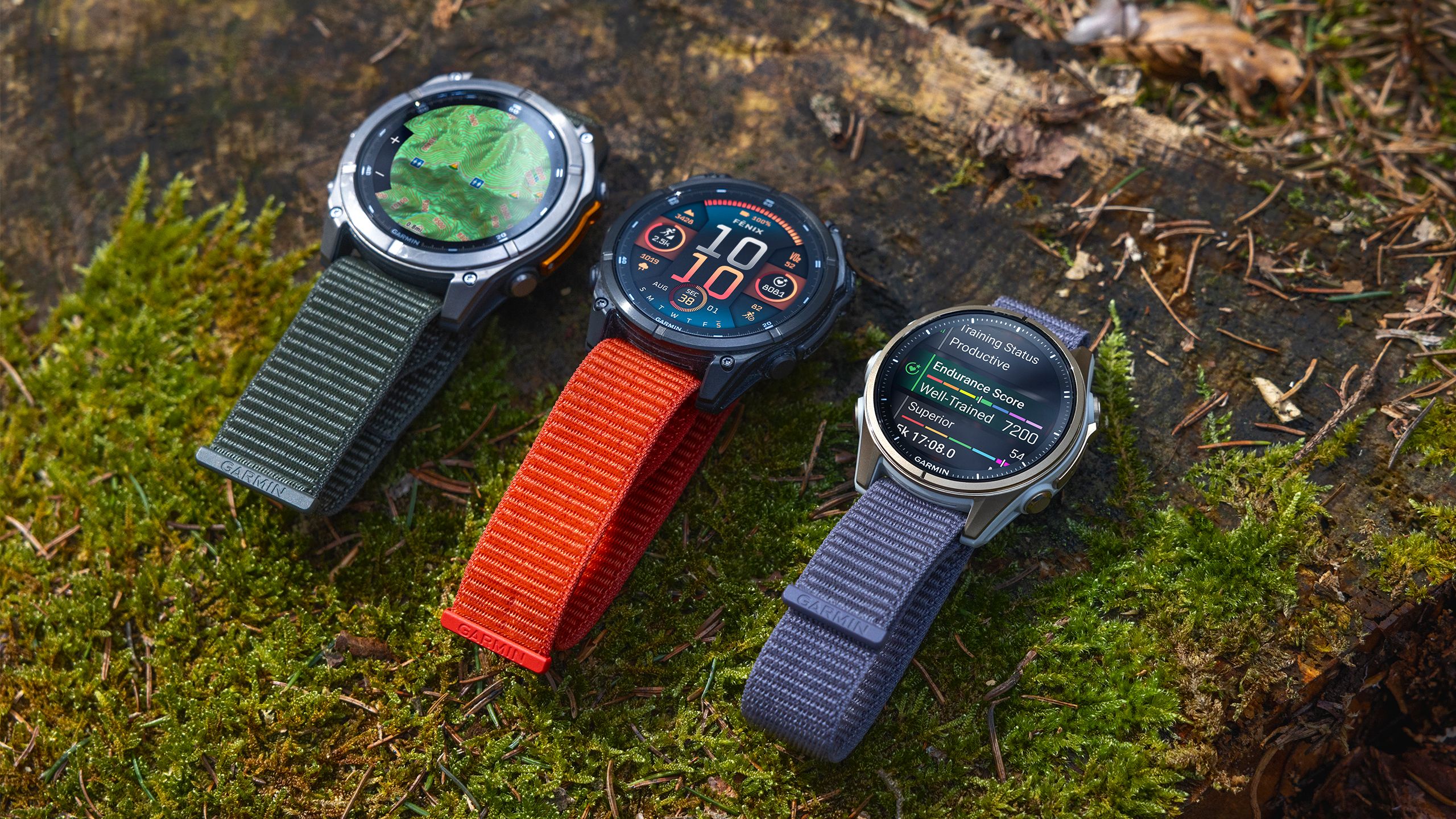 Three Garmin fenix 8 watches are lined up on a mossy ground. 