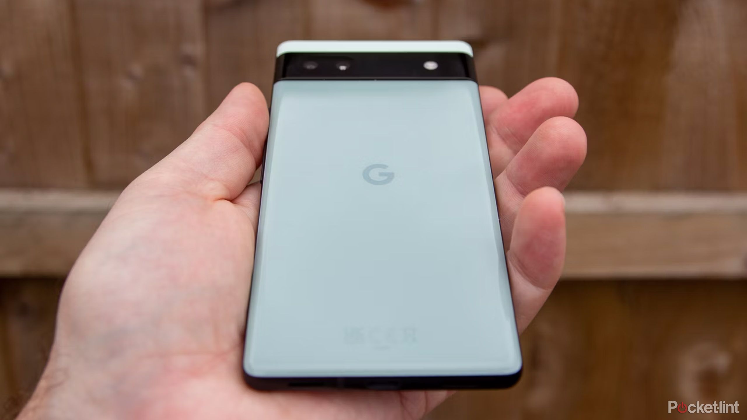 Google Pixel 6A in hand from the bottom up. 