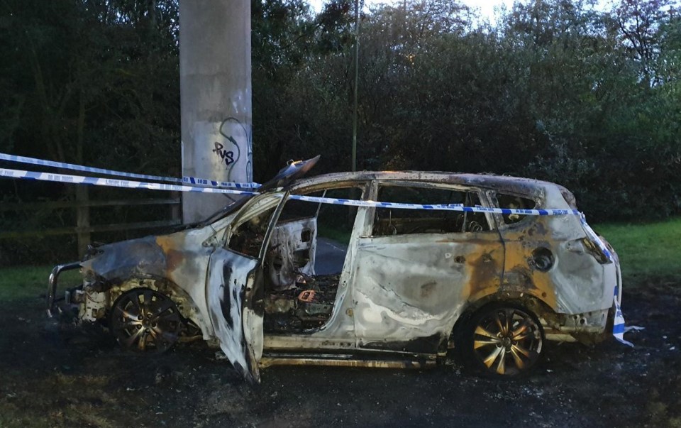 Burned-out car at a crime scene.