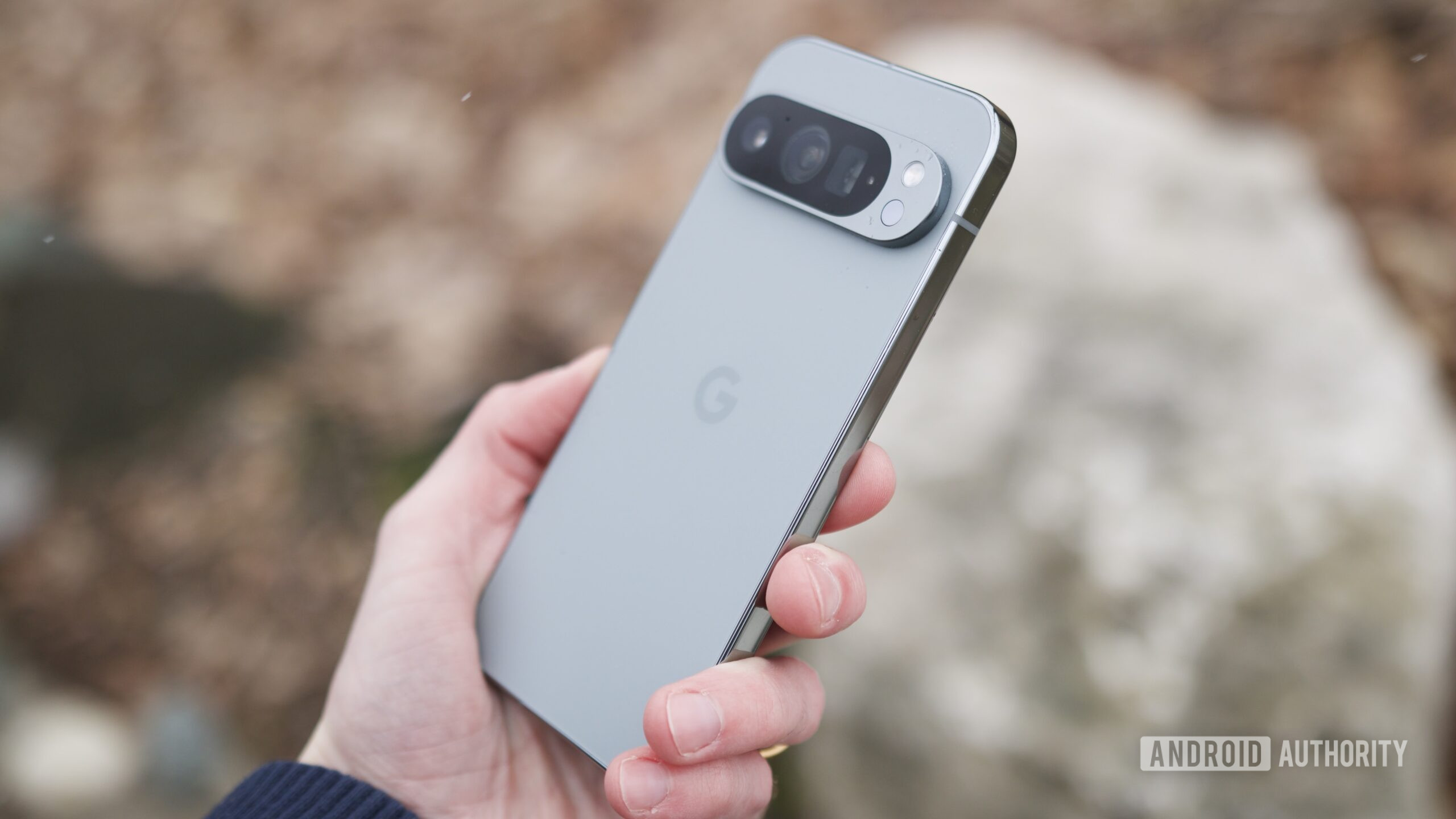 Someone holding the Google Pixel 9 Pro outside.