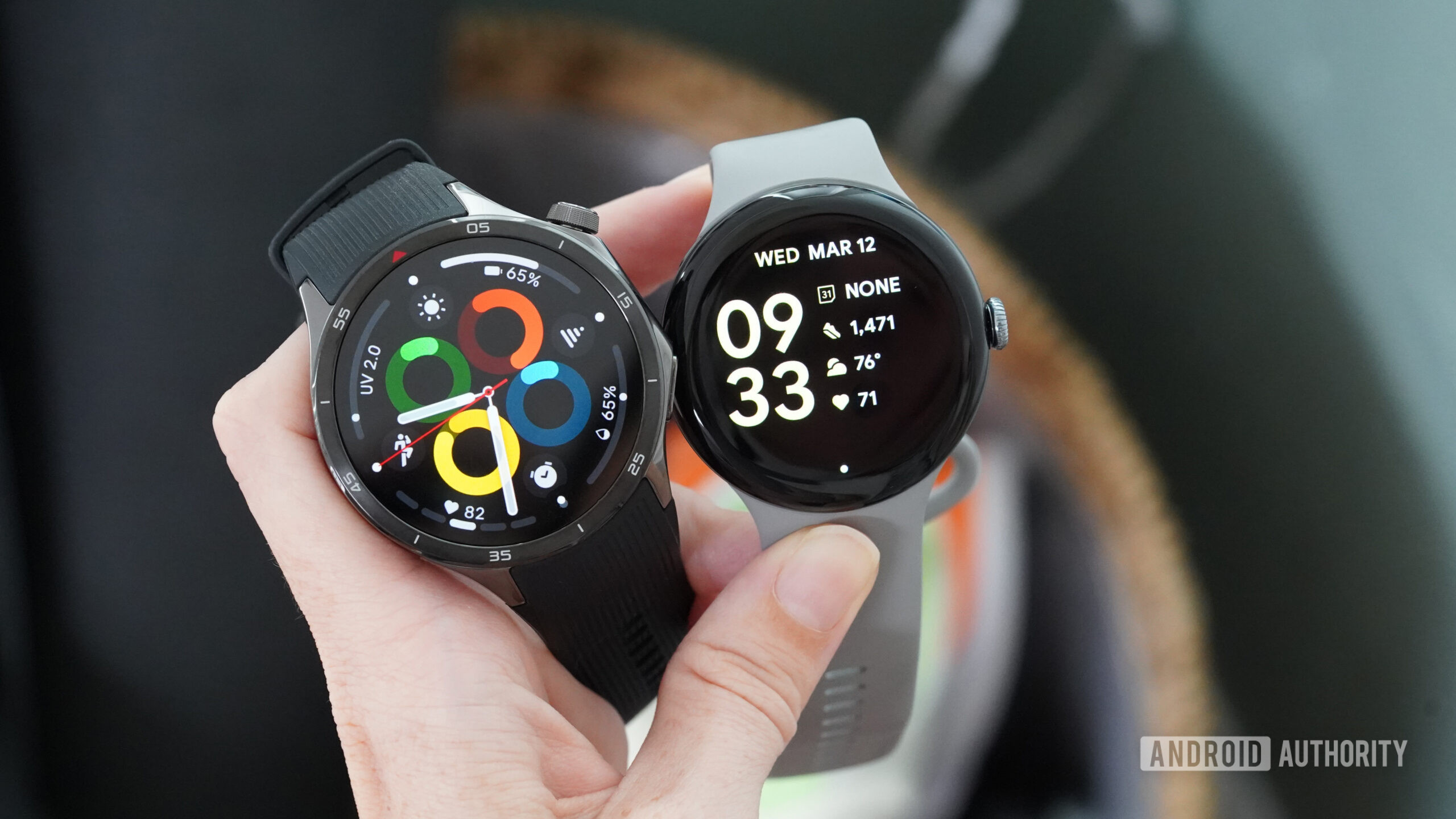 A Wear OS user holds both a Pixel Watch 3 and a OnePlus Watch 3.