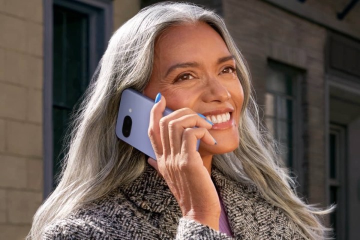 A woman holding a purple Google Pixel 9a.