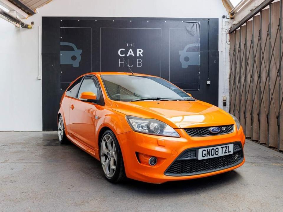 Orange Ford Focus RS parked in front of The Car Hub.