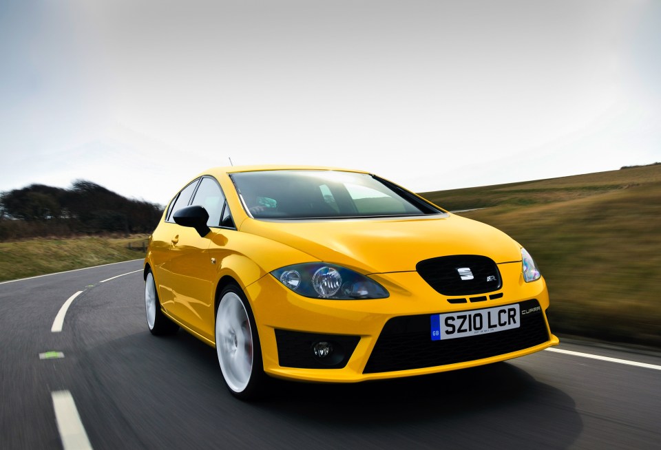 Yellow Seat Leon Cupra R driving on a road.