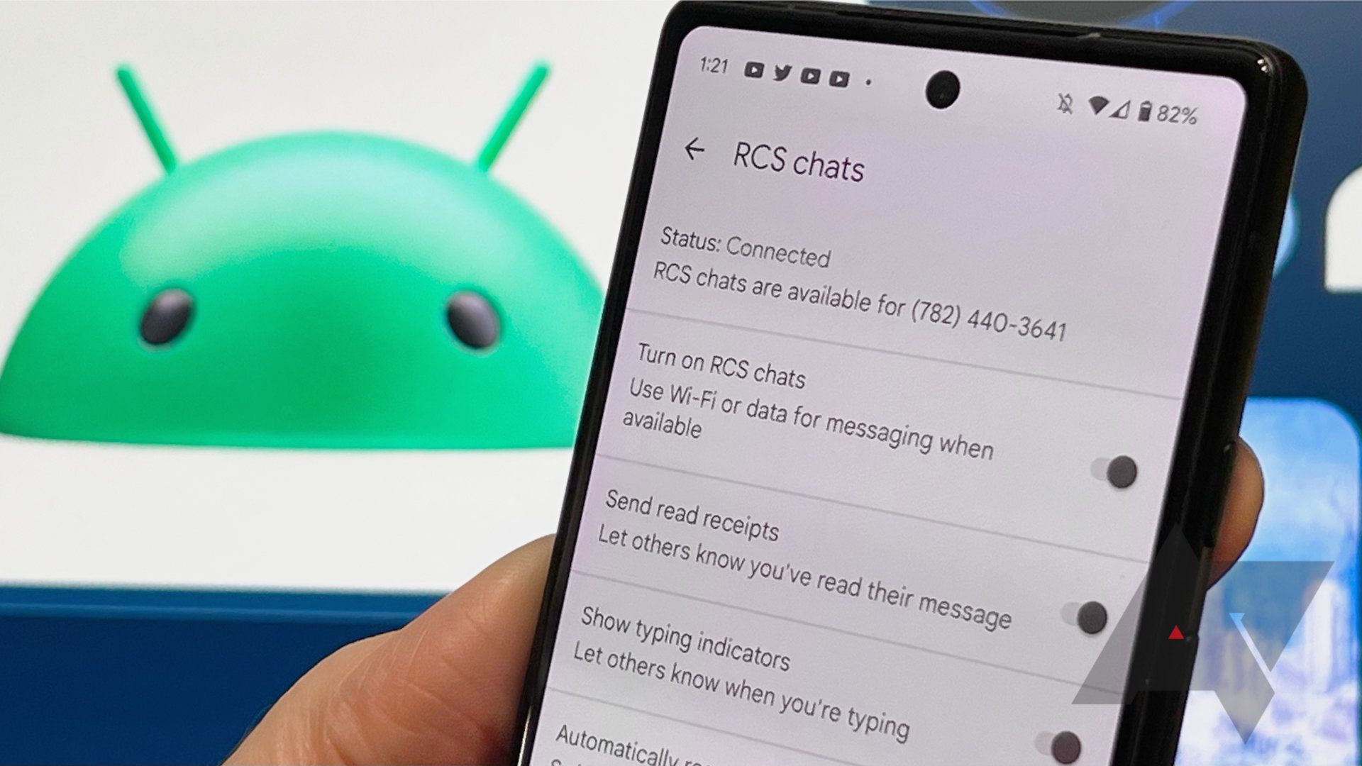 Person holding phone with RCS chat settings on display