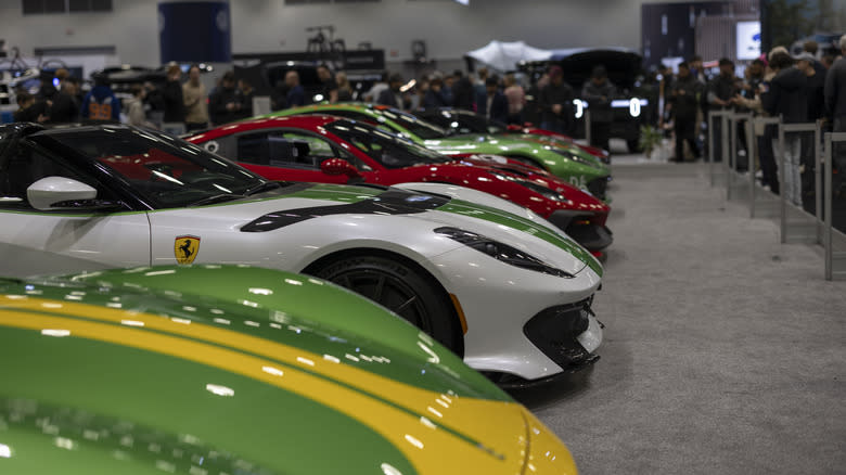 A photo of a line of Ferrari cars at an auto show.