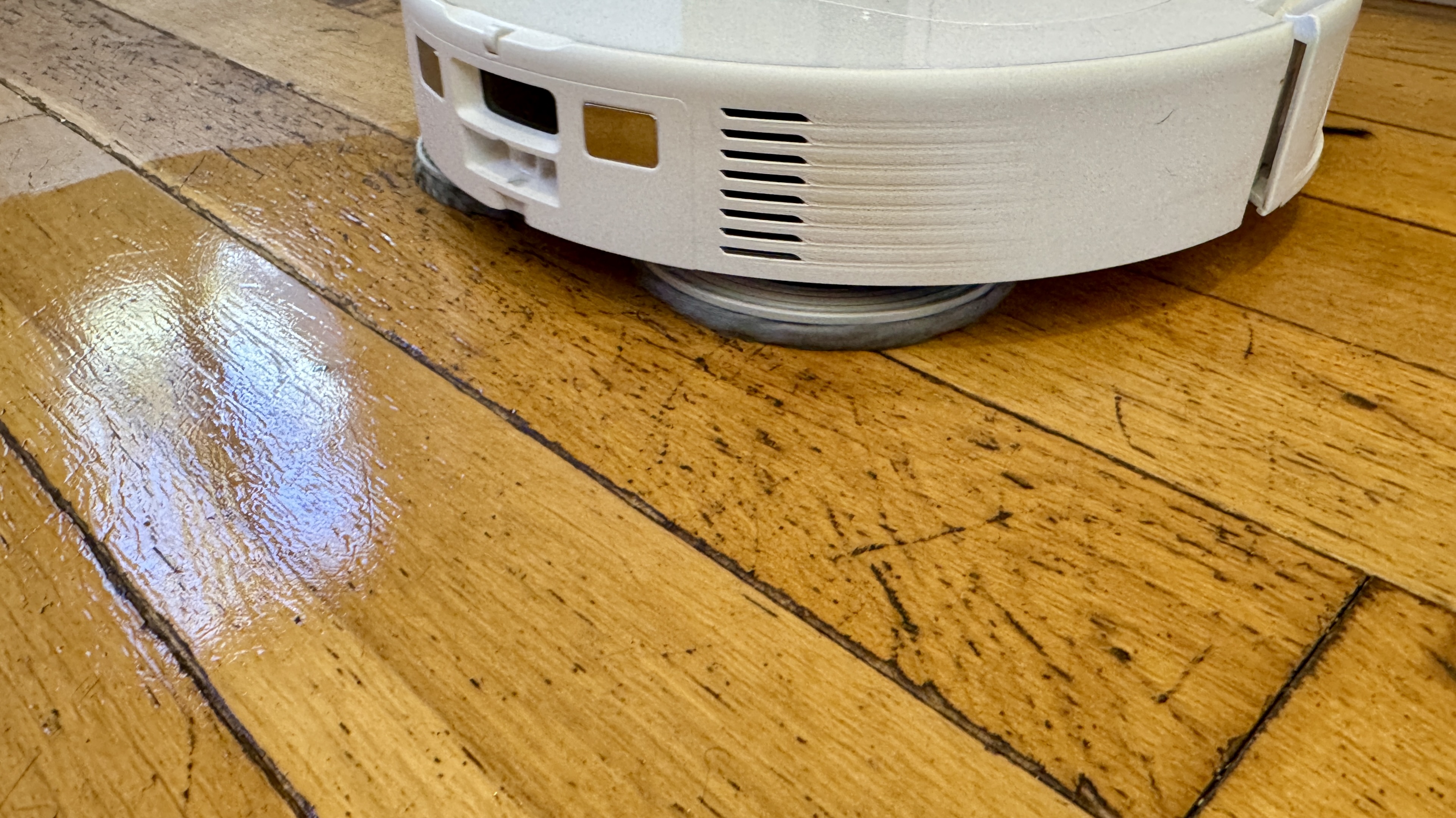Roborock Qrevo Master robot vacuum mopping an engineered wooden floor